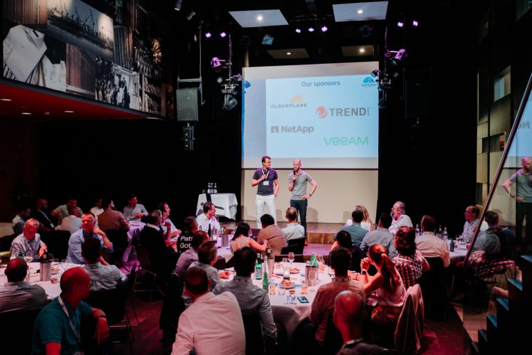 The hosts welcoming the room on stage